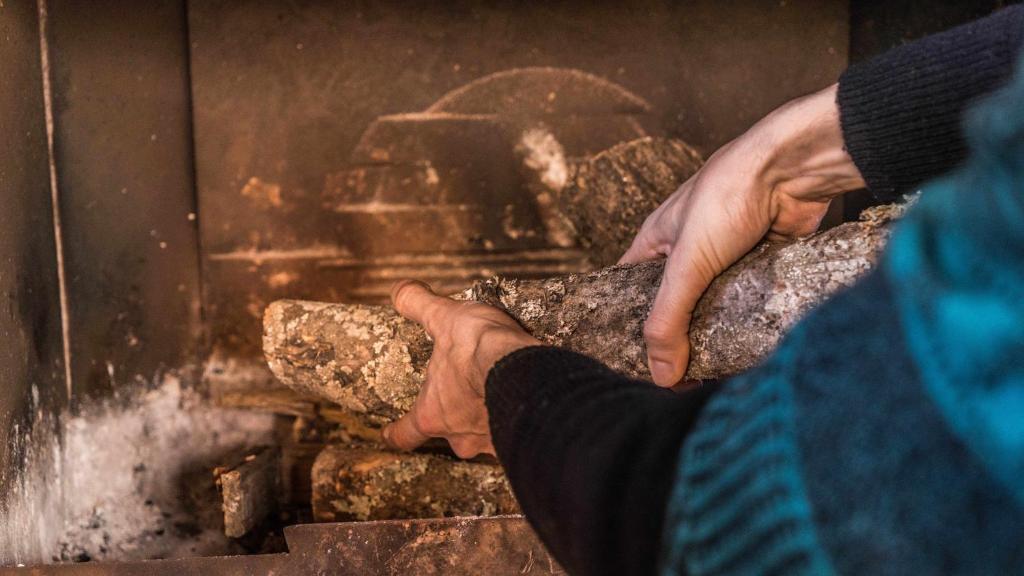 una persona sosteniendo un pedazo de roca delante de un horno en Lagar de Viña Vieja, en Cazalla de la Sierra