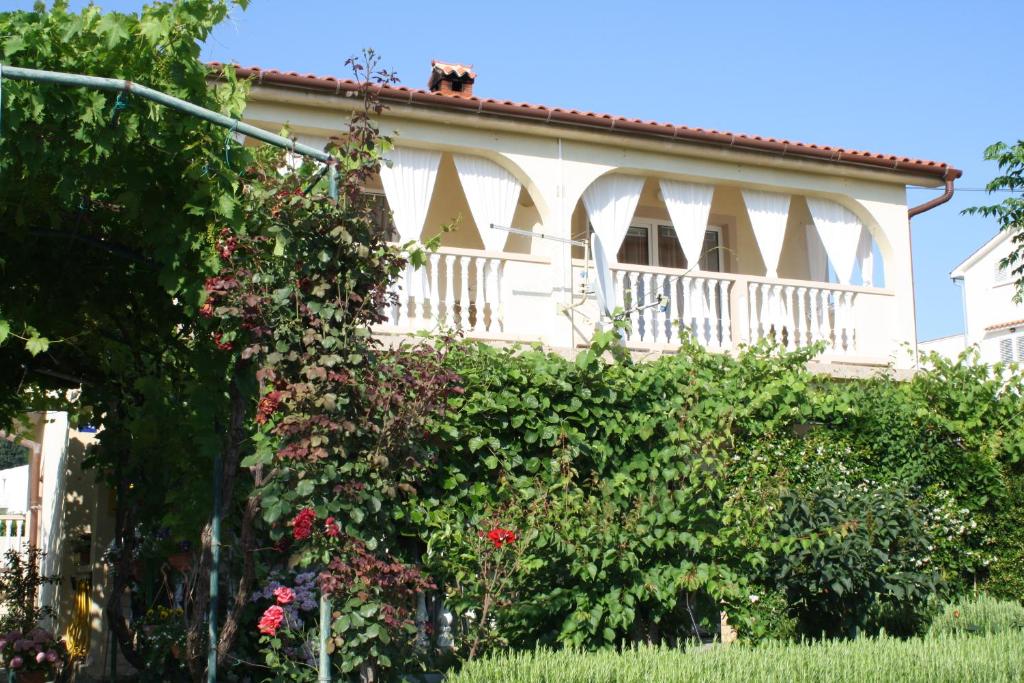 a white house with a dog on the roof at Apartmani Mijatović in Lopar