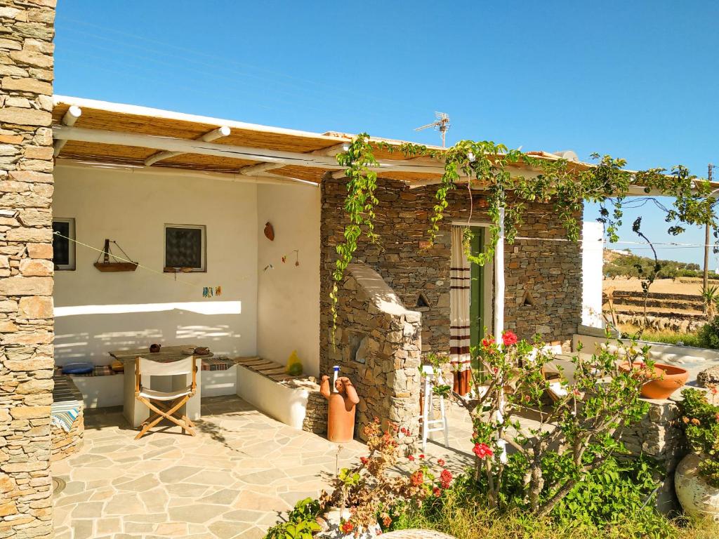 a stone house with a patio with a table at Το Κατἑ in Artemonas