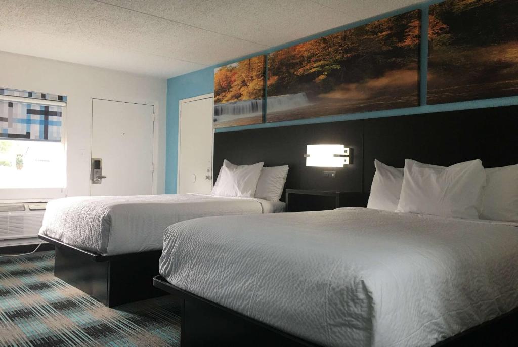 Cette chambre comprend 2 lits et une fenêtre. dans l'établissement Days Inn by Wyndham Calhoun GA I-75 and US-41, à Calhoun