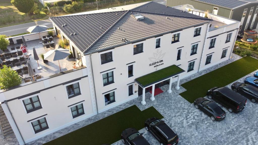 una vista aérea de un edificio con coches aparcados delante en Hotel Sleep & Dream Nähe Europa Park und Rulantica en Ringsheim