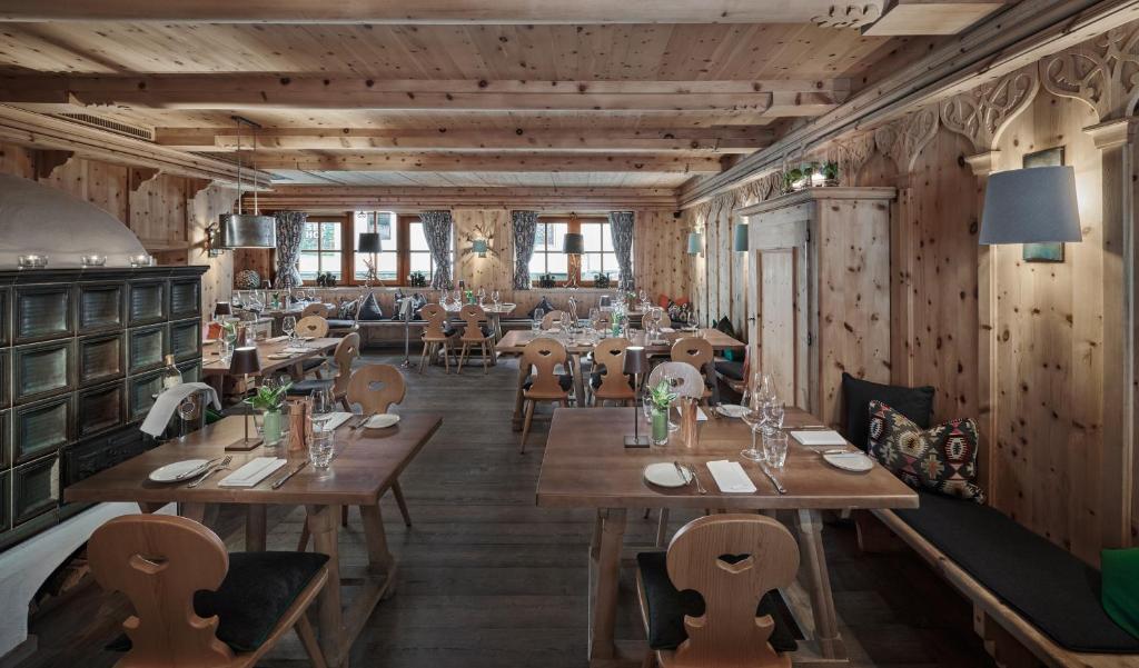 a restaurant with wooden walls and tables and chairs at Schwarzer Adler Kitzbühel - Adults Only in Kitzbühel