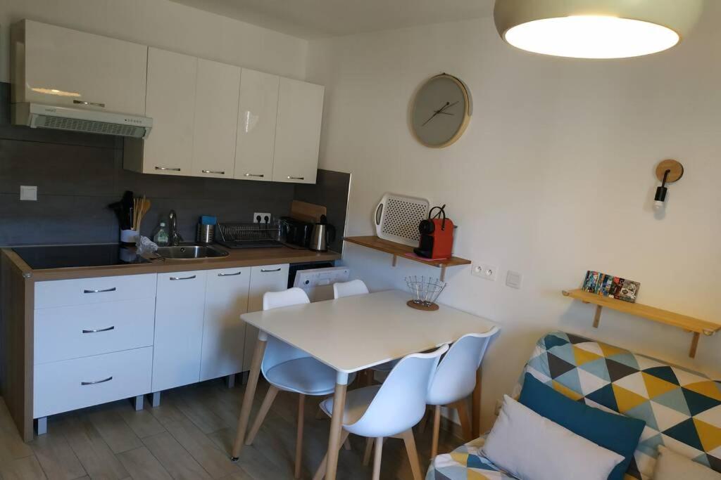 uma cozinha com uma mesa e cadeiras e um lavatório em Appartement refait à neuf ski pied des pistes à Val louron em Val Louron