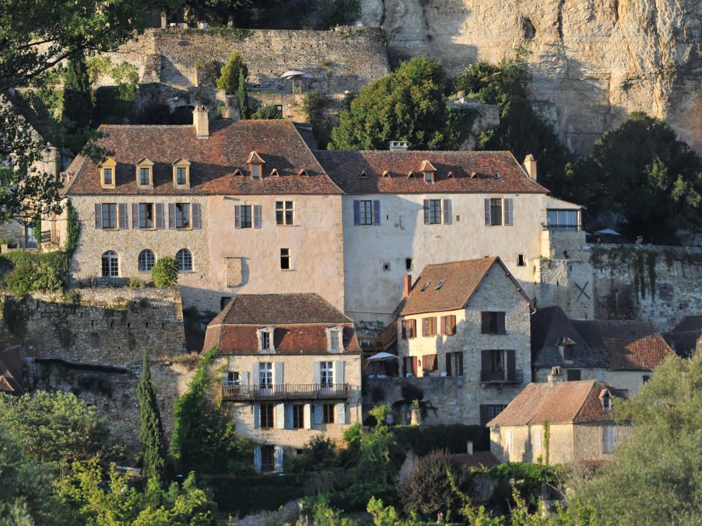 a group of houses on a hill with a mountain at La Maison des Sarrasins in Beynac-et-Cazenac