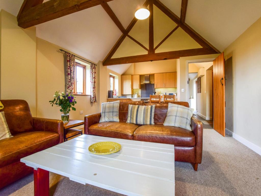 una sala de estar con un sofá y una mesa en Cider House, Oosland Farm, en Bidford