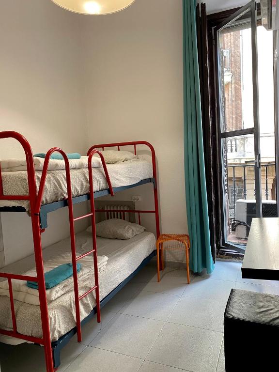 Habitación con 2 literas y ventana en Barbieri Sol Hostel, en Madrid