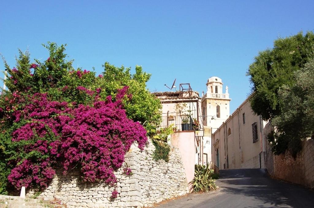 a building with pink flowers on the side of a street at Il Giardino Dei Sospiri in Ragusa