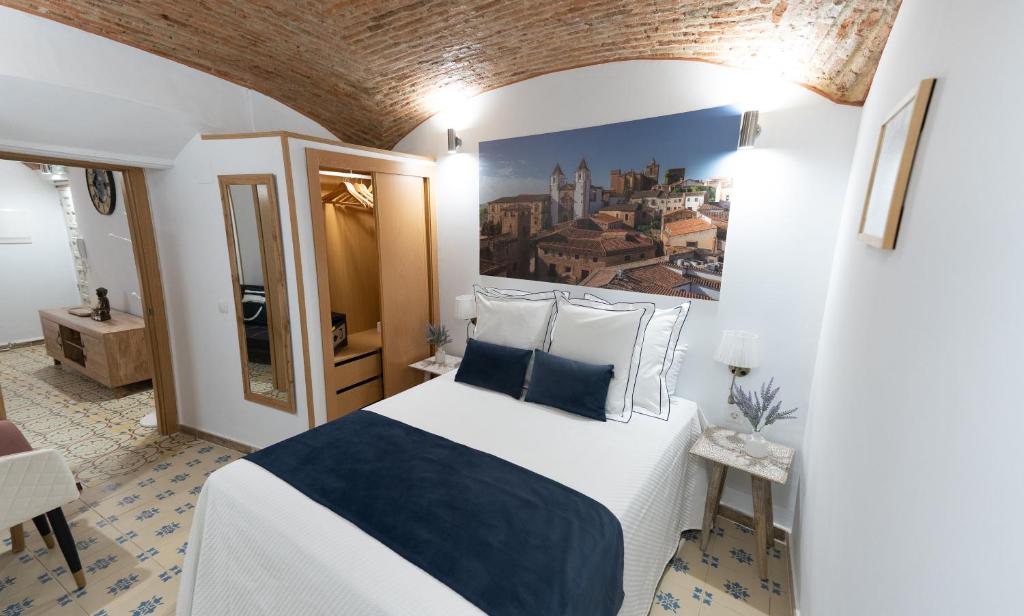 a bedroom with a bed and a painting on the wall at Art & SUITE Apartment Cáceres in Cáceres