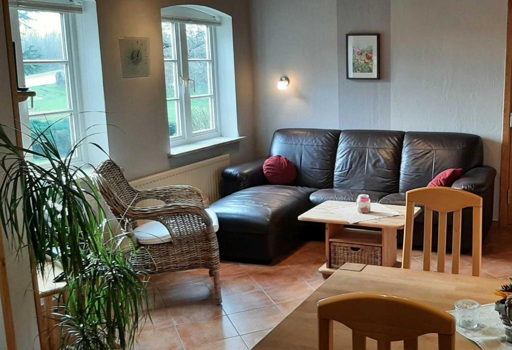 sala de estar con sofá de cuero y mesa en Ferienhaus Geltinger Birk, en Gelting