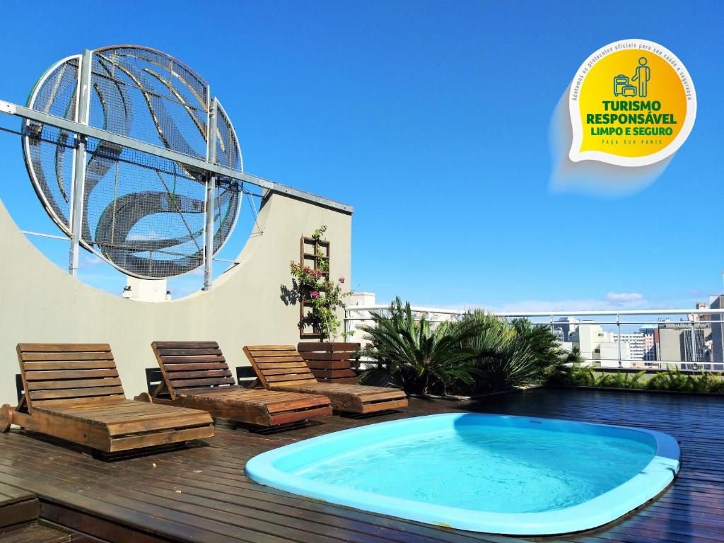 a patio with chairs and a large pool on a deck at Eko Residence Hotel - a 200m dos Hospitais da Santa Casa in Porto Alegre