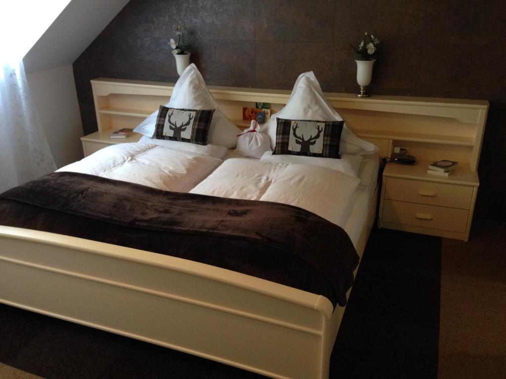 a bedroom with a large bed with two pillows at Mosel-Pension Gästehaus Christiane, Brodenbach in Brodenbach