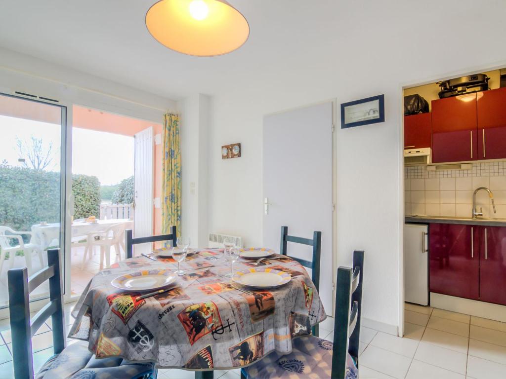 une salle à manger avec une table et une cuisine dans l'établissement Apartment Les Rives du Lac-6 by Interhome, au Grau-du-Roi