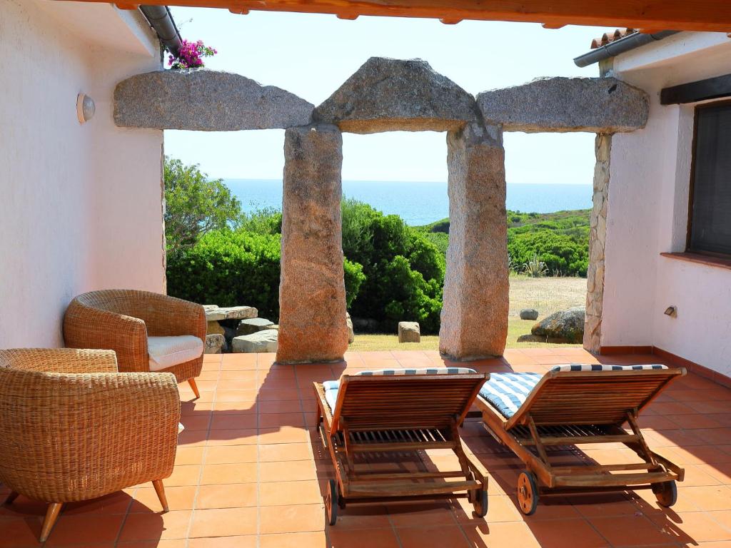 un patio con sillas y vistas al océano en Holiday Home Ville Sant'Elmo - REI240 by Interhome, en Monte Nai