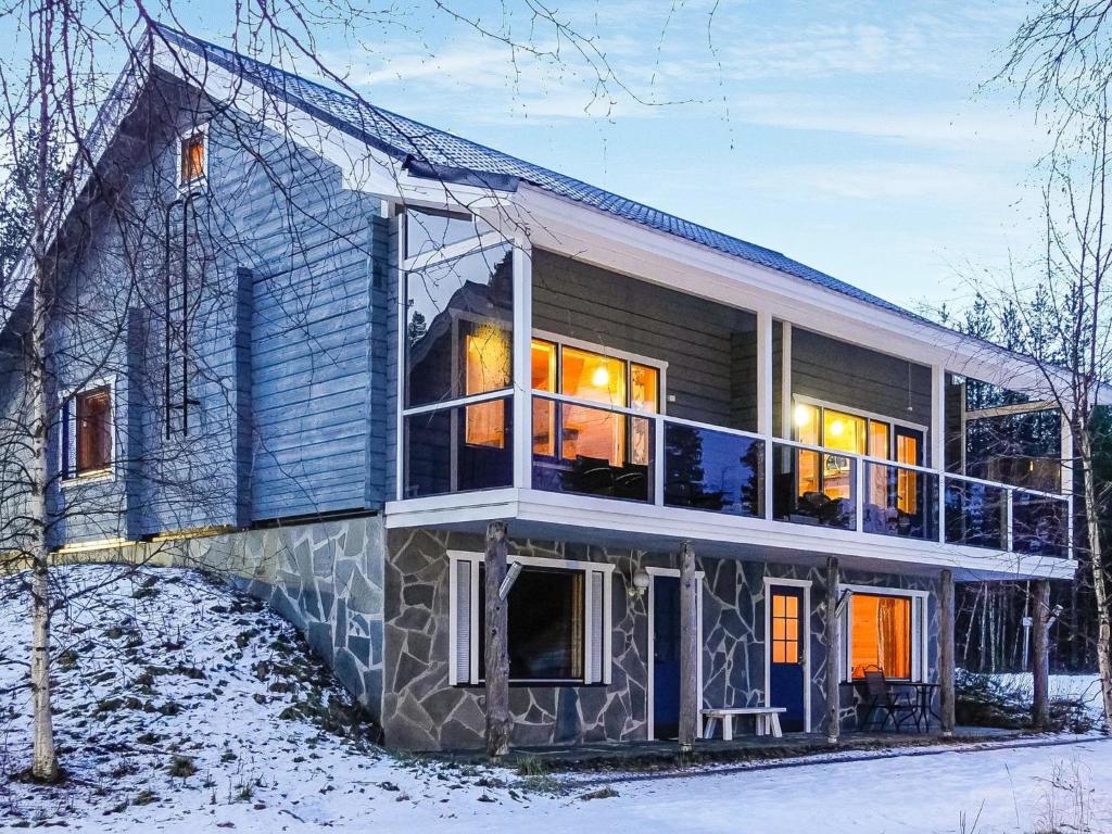una casa rodeada de un porche en la nieve en Holiday Home Äkäsjärven lomamökit 1 by Interhome, en Rauhala