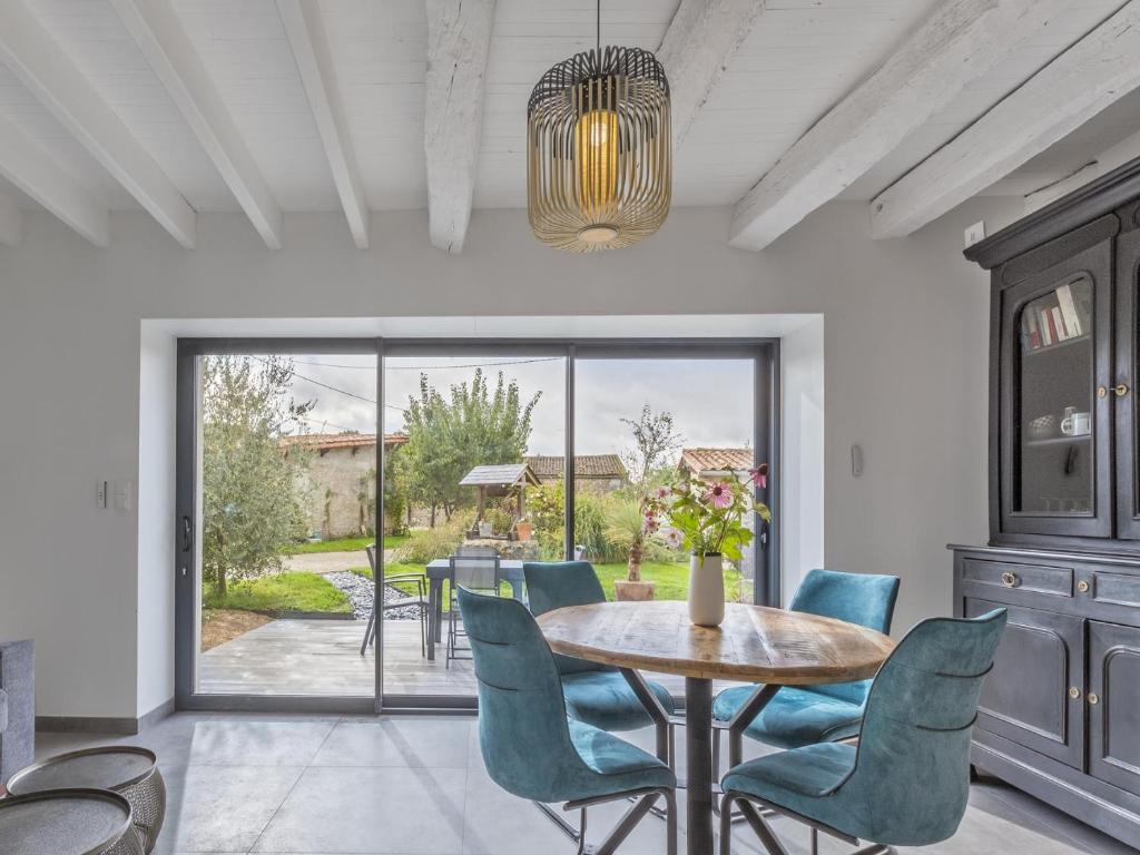 uma sala de jantar com mesa e cadeiras em La Marceline gîte Confort et Nature em Chef-Boutonne