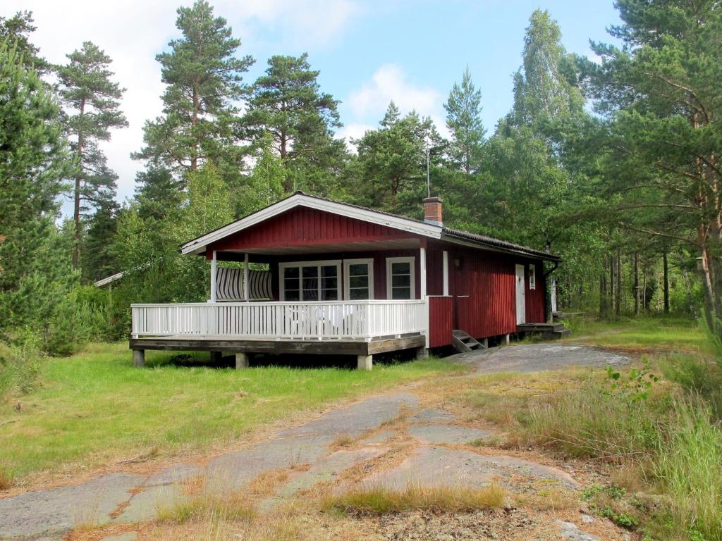 uma casa vermelha no meio de uma floresta em Chalet Forsviken - VMD049 by Interhome em Karlstad