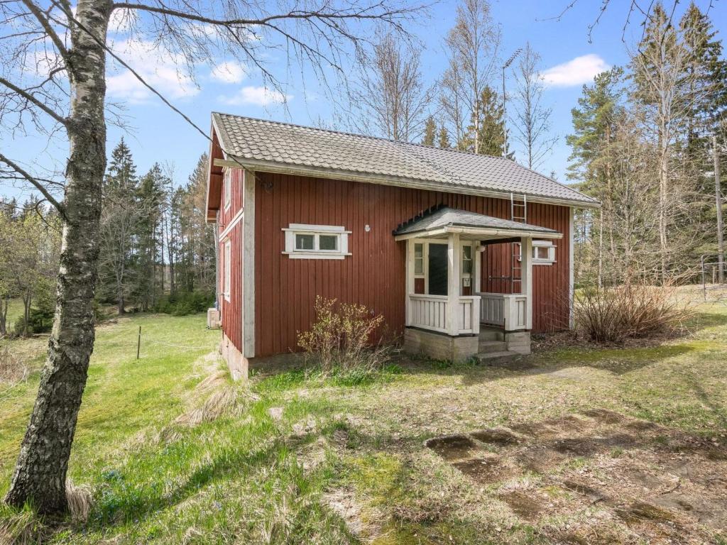 a small red house in the middle of a field at Holiday Home Mäkitupa by Interhome in Laiterla