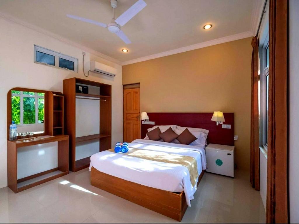 um quarto com uma cama grande e uma janela em Sunset Beach View em Dhangethi