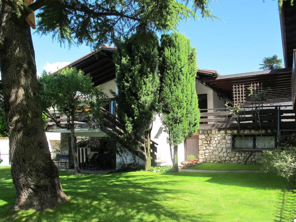 een huis met een gazon en bomen ervoor bij Holiday Home Rocchetta by Interhome in Malcesine