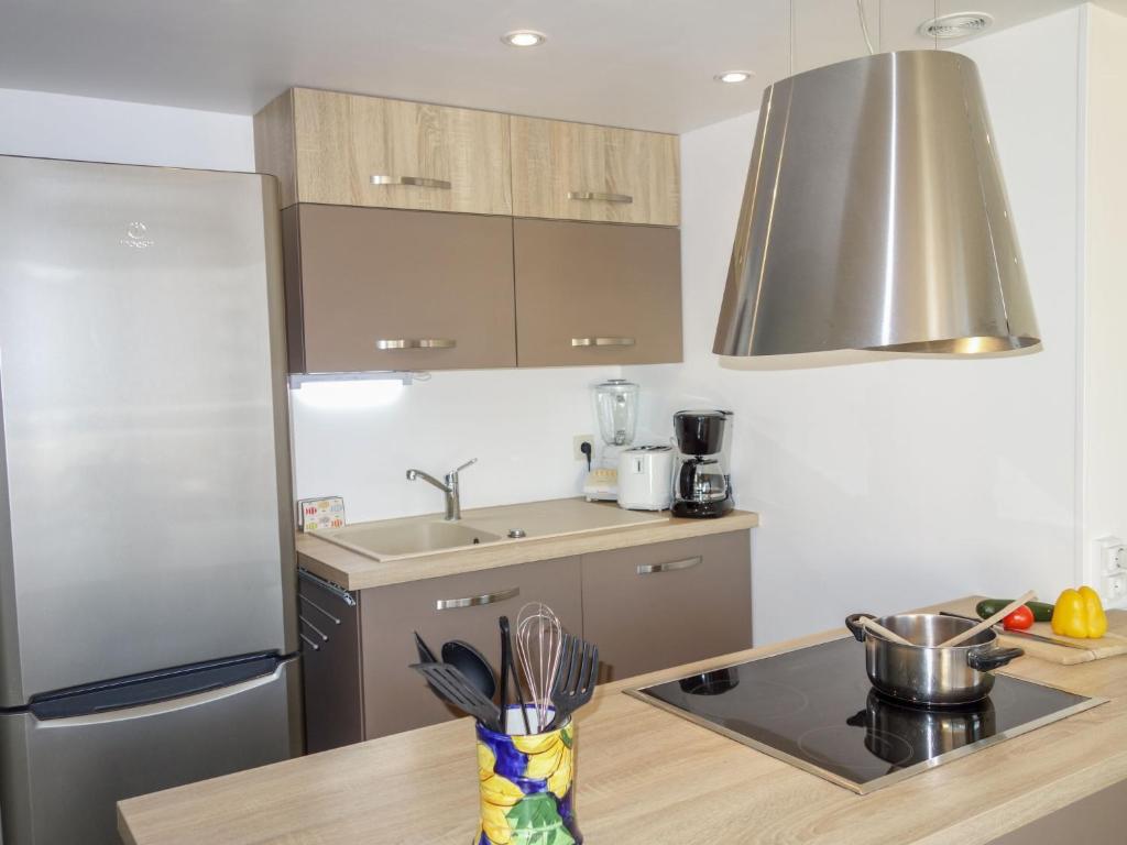 eine Küche mit einem Kühlschrank aus Edelstahl und einer Spüle in der Unterkunft Apartment Le Myflower by Interhome in Le Grau-du-Roi