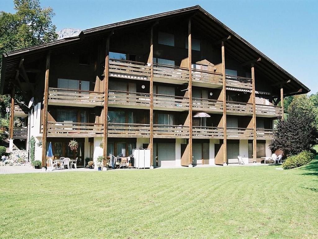 ein großes Gebäude mit Rasen davor in der Unterkunft Apartment Ammerten A17 by Interhome in Lenk im Simmental