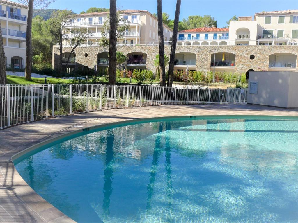 a swimming pool in front of a building at Apartment Le Domaine-1 by Interhome in Cavalaire-sur-Mer