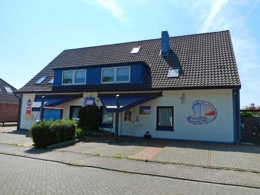 een blauw-wit huis met een zwart dak bij Apartment Backbord by Interhome in Norddeich