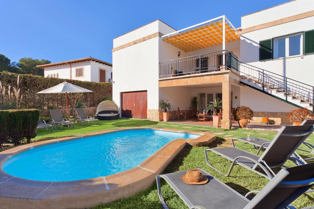 een huis met een zwembad in de tuin bij Villa Son Veri Miramar in El Arenal