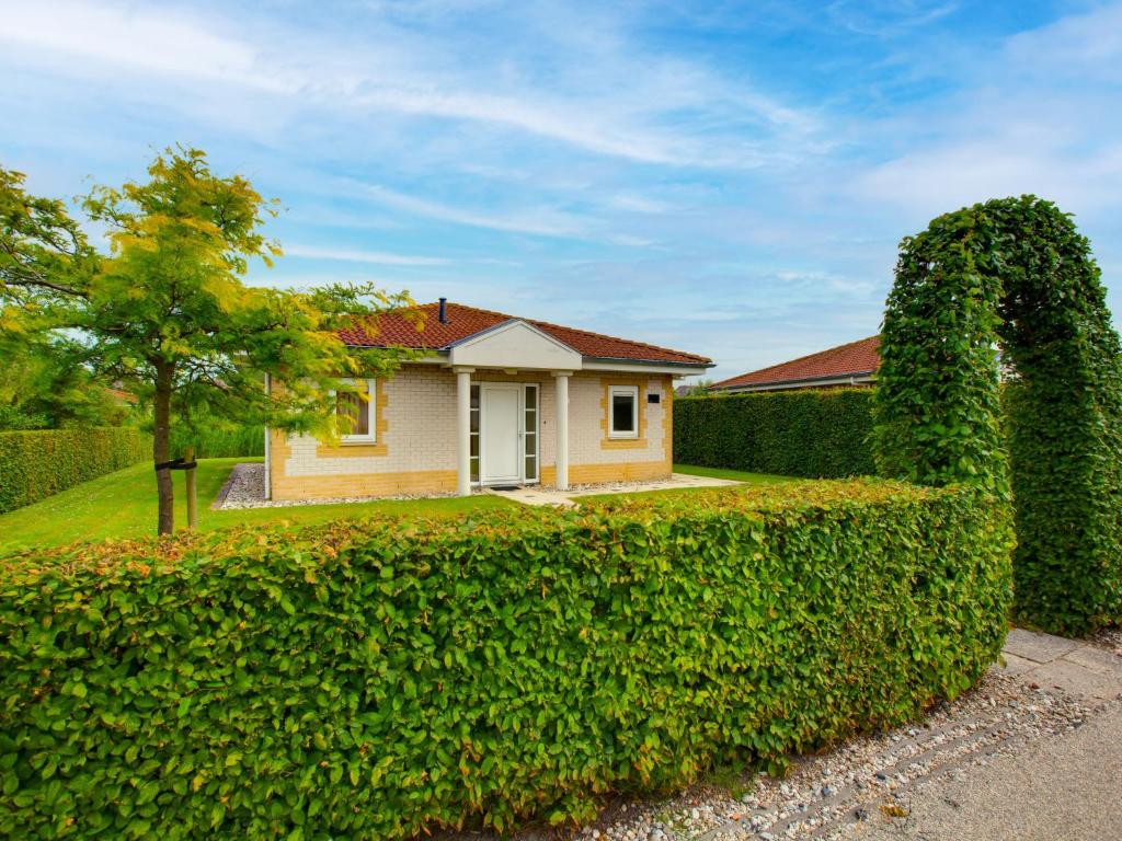 a house with a hedge in front of it at Holiday Home Citta Romana-1 by Interhome in Hellevoetsluis