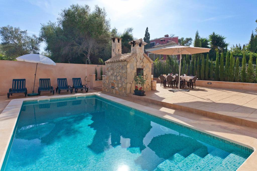 a swimming pool with a table and an umbrella at Bellavista in Cala Blava