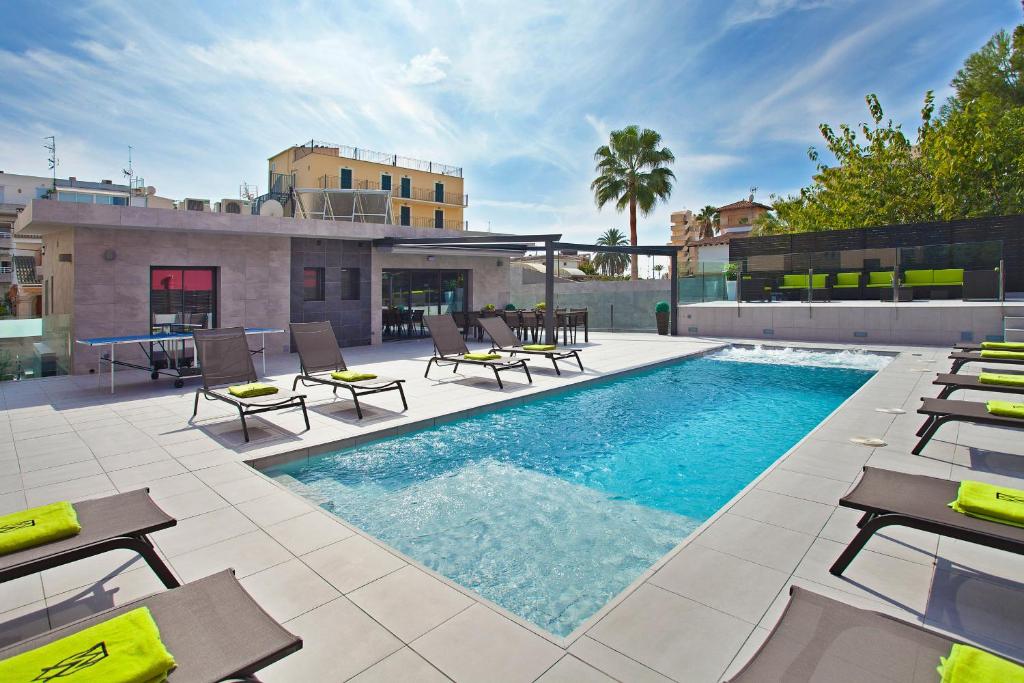 a swimming pool with chairs and a table on a building at Villa Maravilla in San Francesch