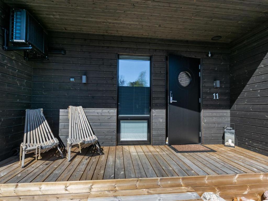 2 sillas sentadas en una terraza de madera frente a una puerta en Holiday Home Kasnäs marina b11 by Interhome en Kasnäs