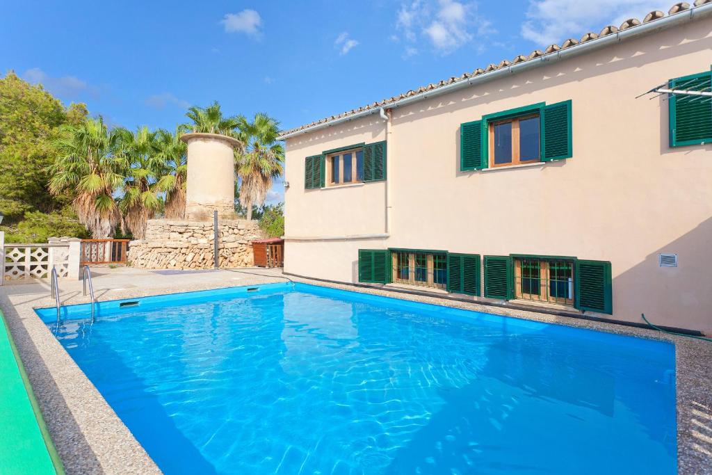 a villa with a swimming pool in front of a house at Cas Fideuer in Palma de Mallorca