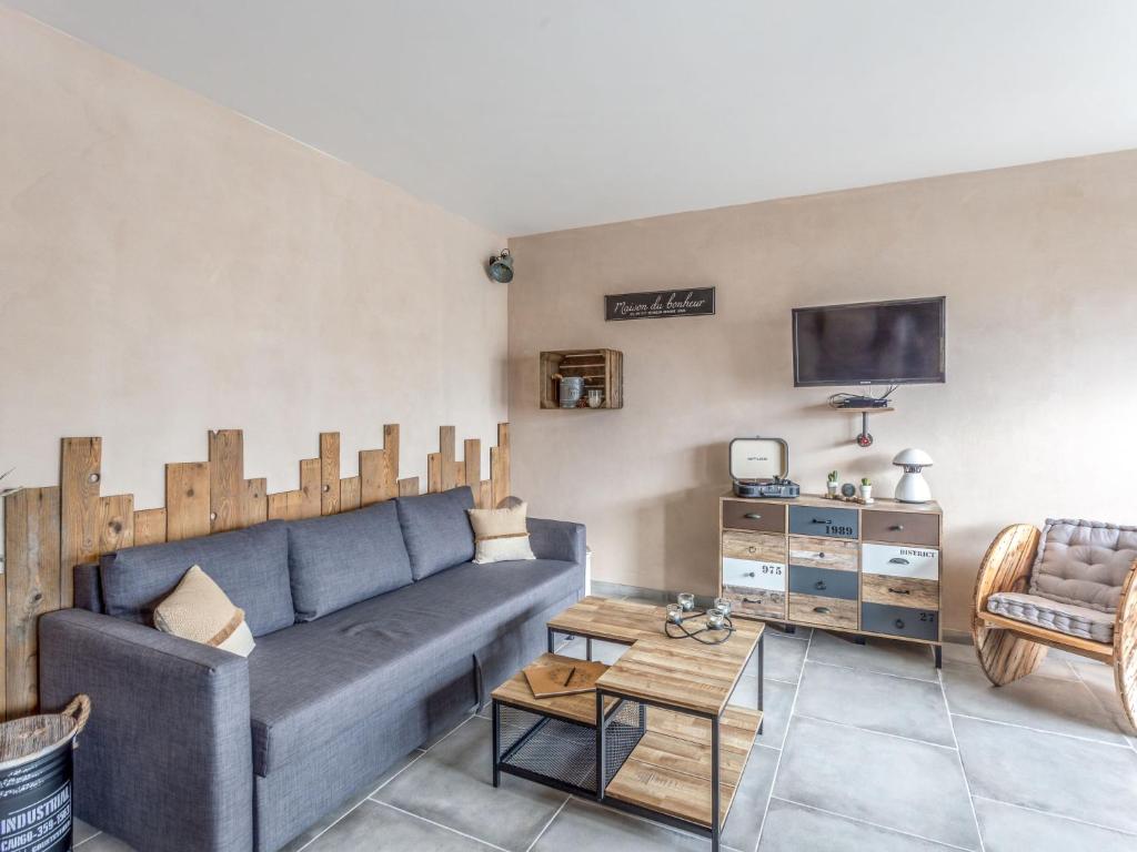 un salon avec un canapé bleu et une télévision dans l'établissement Apartment L'Amirauté by Interhome, à Hyères