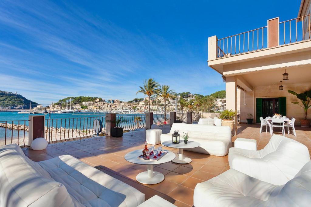 un patio con muebles blancos y vistas al océano. en Sa Caleta, en Puerto de Sóller