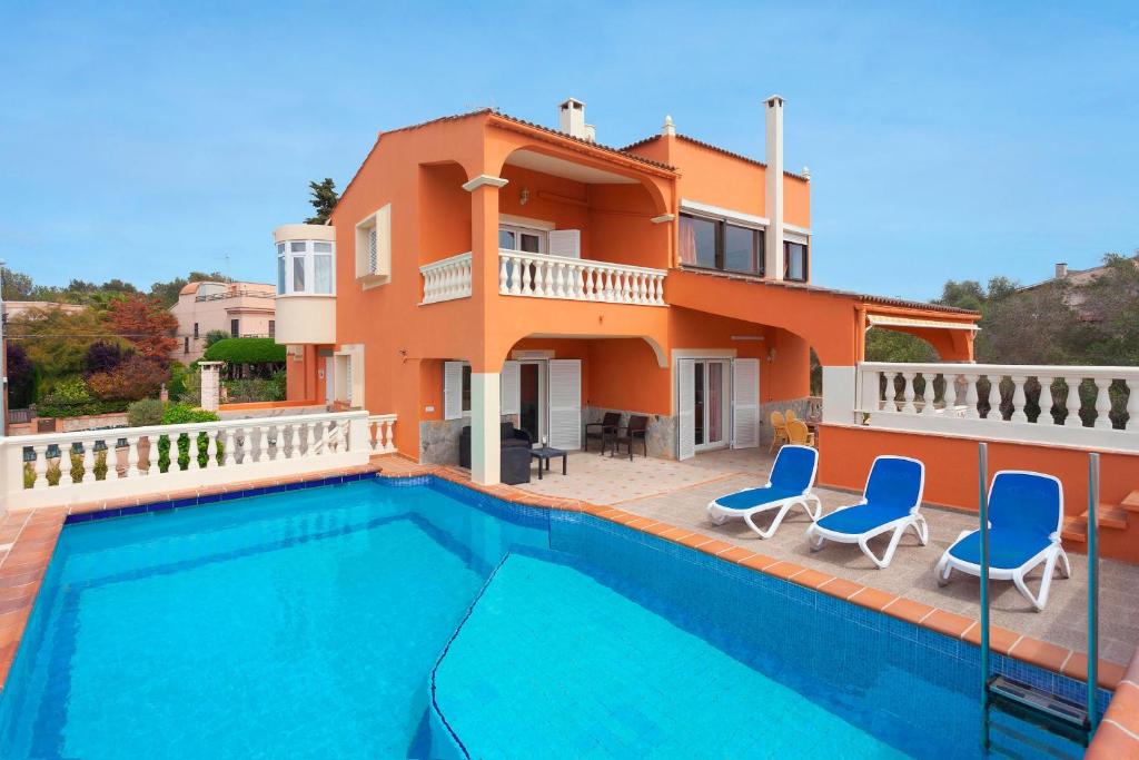 eine Villa mit einem Pool vor einem Haus in der Unterkunft Villa Lirica in Cala Blava