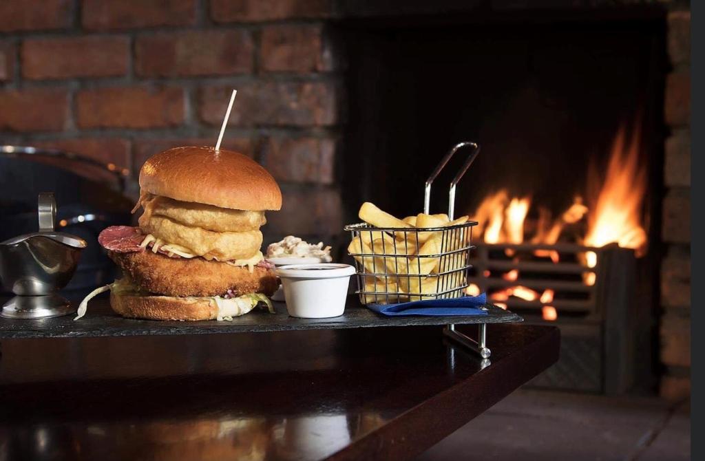 a sandwich and a basket of food next to a fireplace at The Port Hotel in Portrush