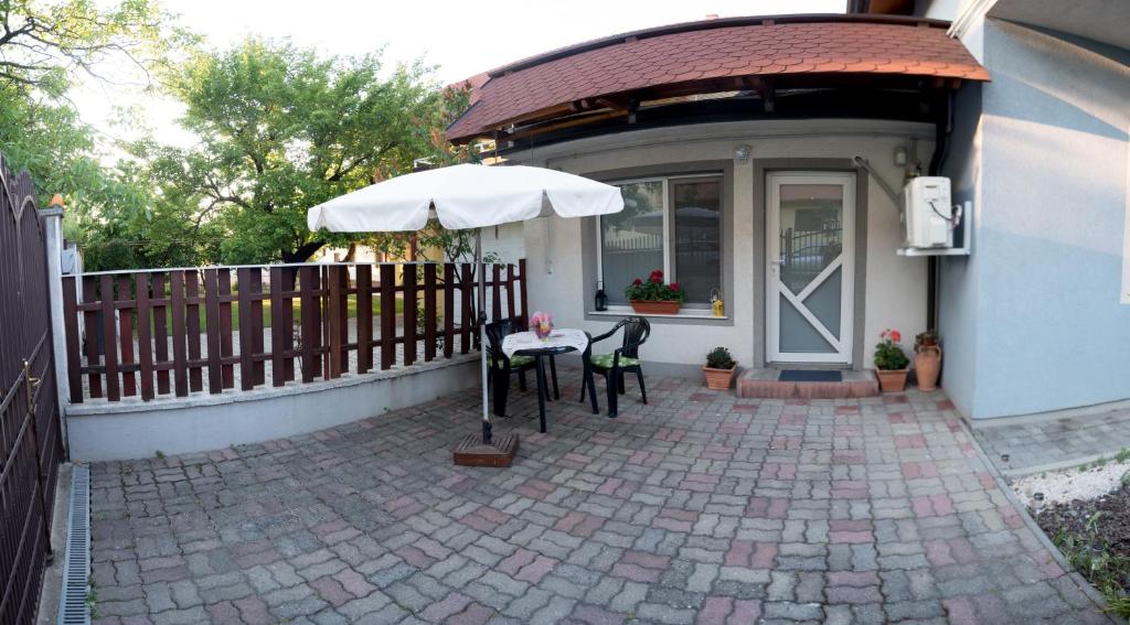 a patio with a table and an umbrella in front of a house at Cassa Blue in Timişoara
