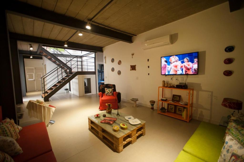 uma sala de estar com um sofá e uma televisão em Gaia Hostel no Rio de Janeiro