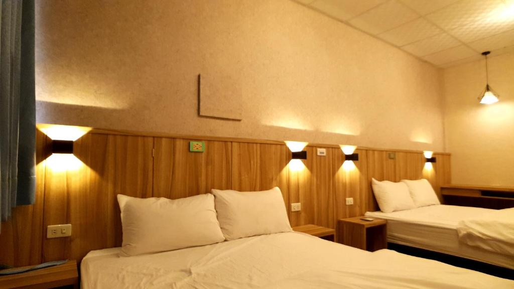 潮州鎮的住宿－多元化民宿，酒店客房,设有两张床,墙上有灯