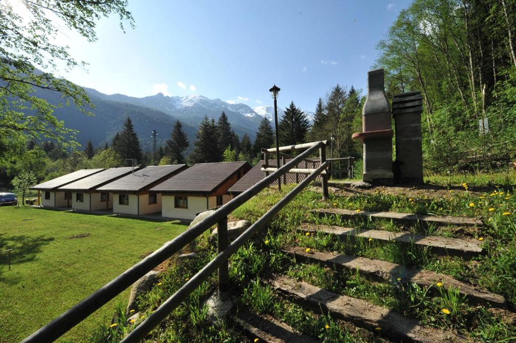 a set of stairs leading to a building with mountains in the background at Chalet Presanella in Temù