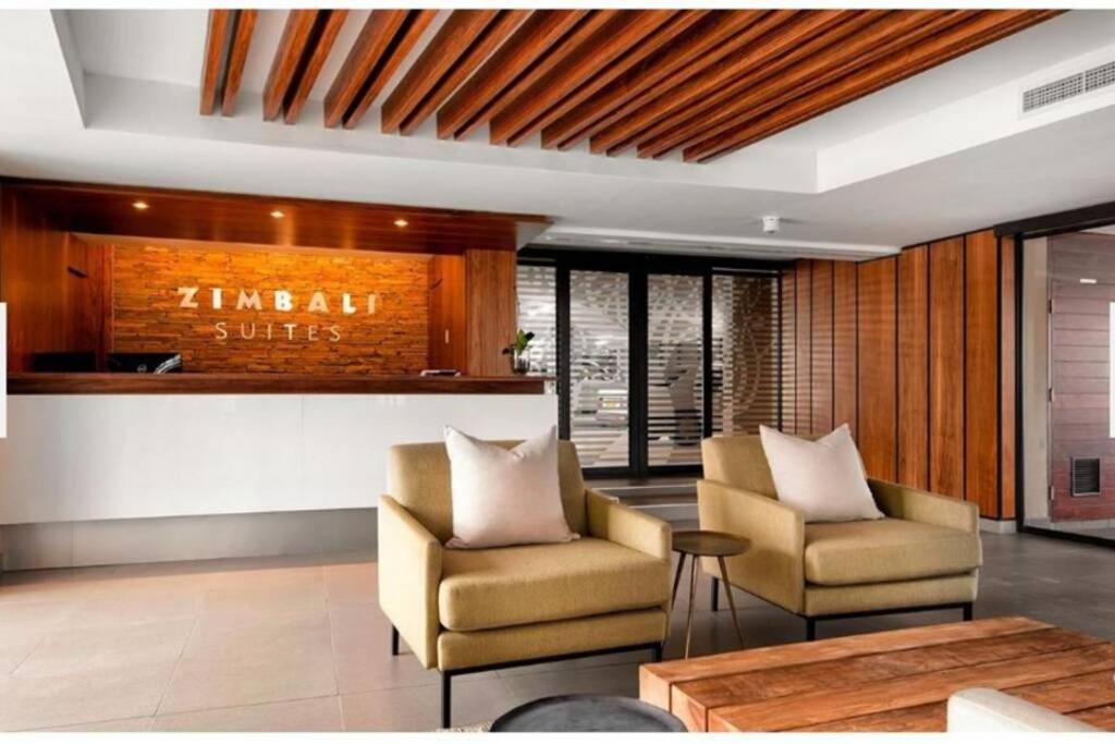 a lobby with two chairs and a table and a bar at Zimbali Suite 112 in Ballito