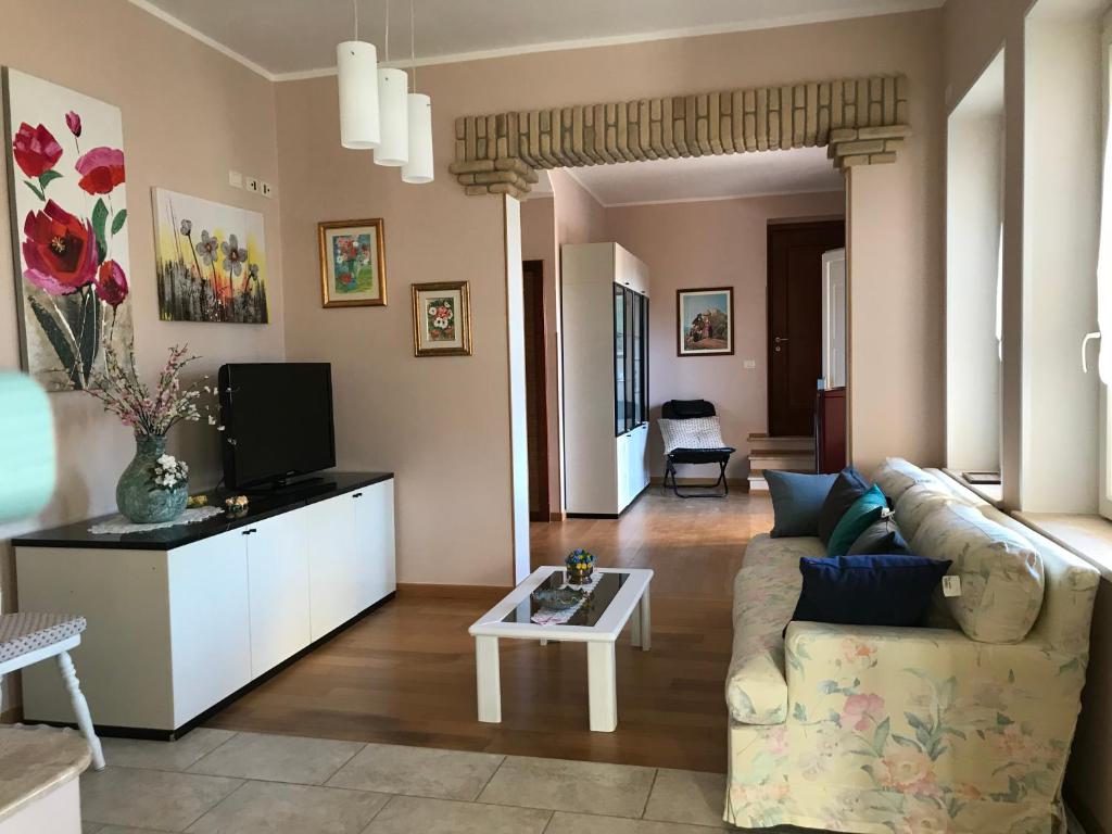uma sala de estar com um sofá e uma televisão em Villa Dei Fiori - casa vacanza em Capoterra