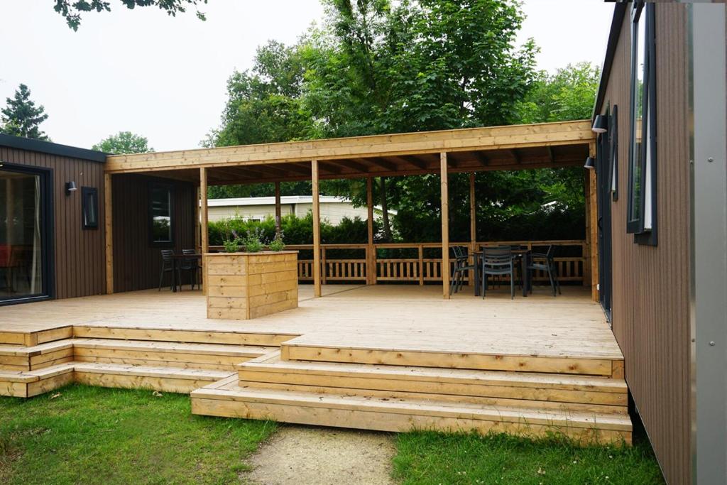 a large deck with a table and a pavilion at 6 6-persoons Familie lodge in Voorthuizen