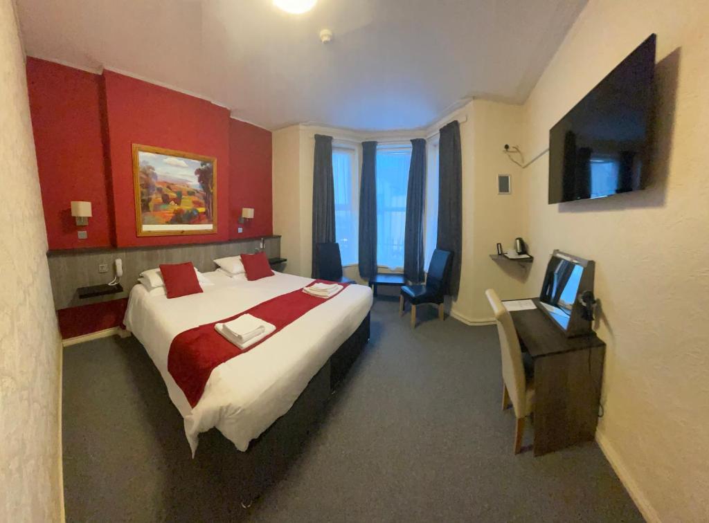 a hotel room with a bed and a television at The Port Hotel in Portrush