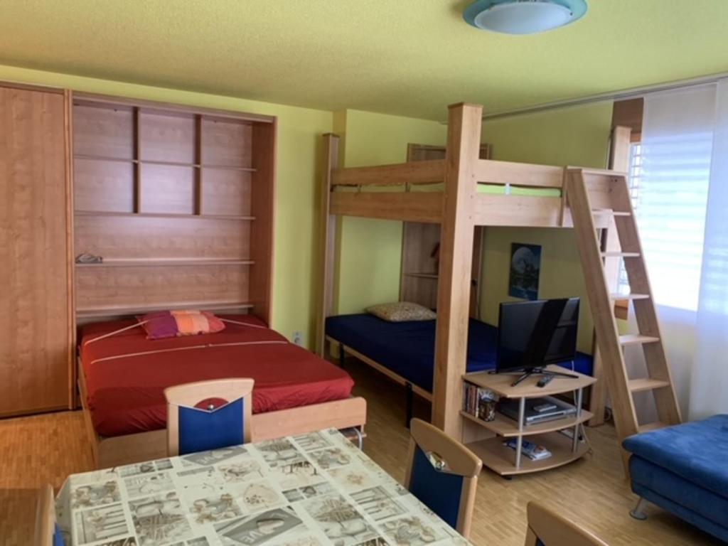 1 Schlafzimmer mit 2 Etagenbetten und einem Schreibtisch mit einem Computer in der Unterkunft Davos Lodge by Quokka 360 - practical apartment for skiers in Davos