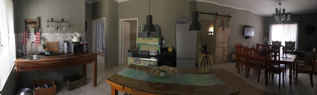 a kitchen and living room with a table and a counter top at Spinoza Self Catering Accommodation in Windhoek