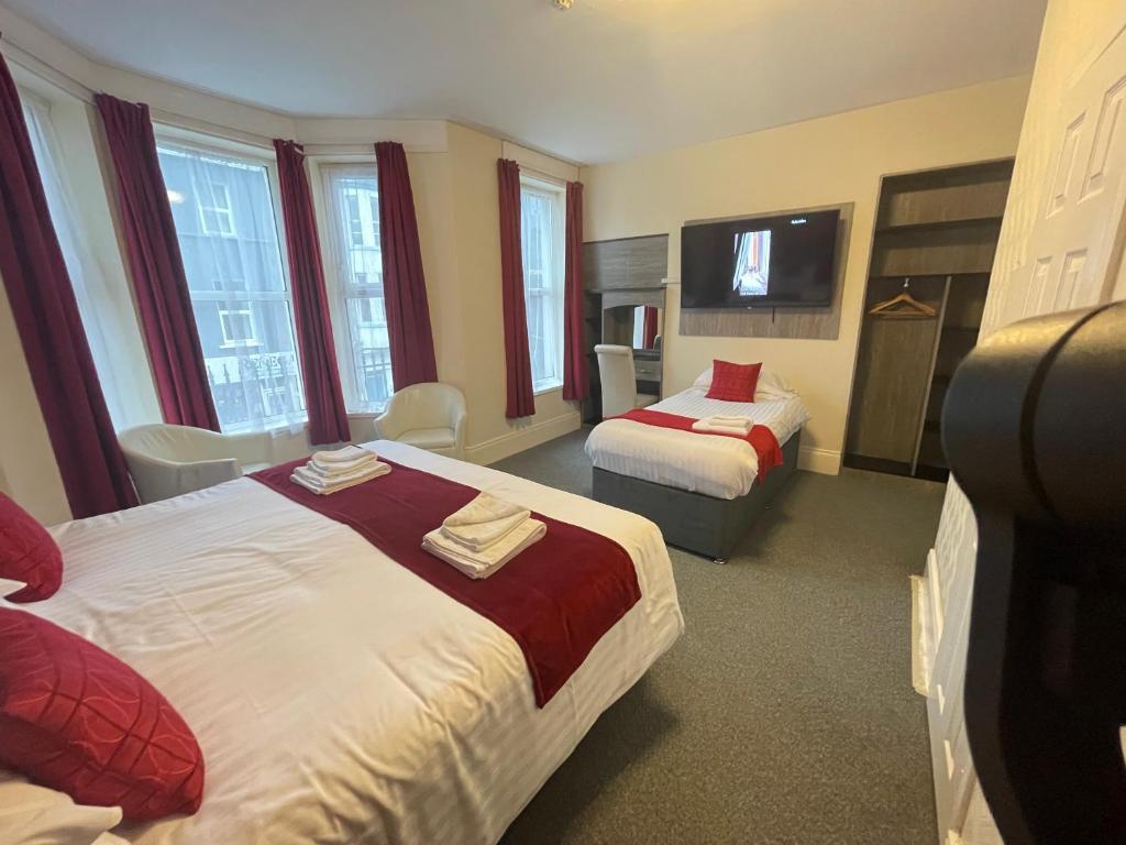 a hotel room with two beds and a television at The Port Hotel in Portrush