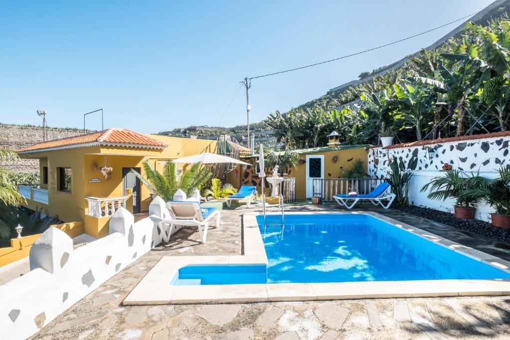 a villa with a swimming pool in front of a house at Finca Alejandrina in La Guancha