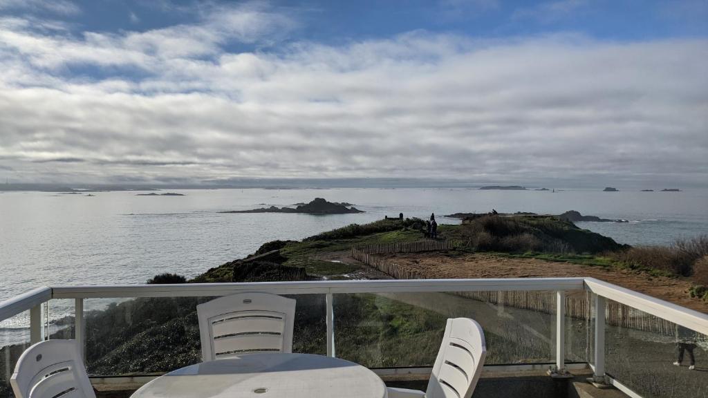 d'un balcon avec des chaises et une vue sur l'océan. dans l'établissement La Conchee, à Saint-Malo